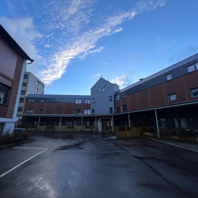 fasade på borettslag med parkeringsplass